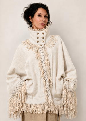 Fringe Poncho bianco in 100% cotone indossato, con collo alto strutturato, bottoni e frange.