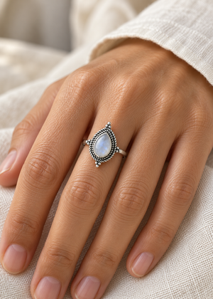 Anello Selene in argento con pietra chiara a goccia indossato sulla mano, copertina
