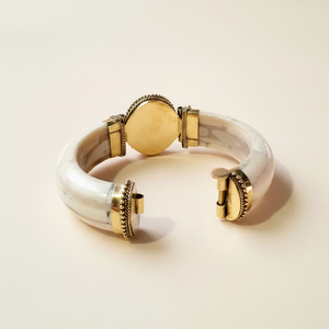 Bracciale rigido bianco in osso con terminali decorati in ottone e chiusura a perno