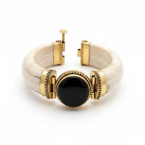 Bracciale rigido in osso bianco con grande pietra rotonda di onice nero e decorazioni in ottone