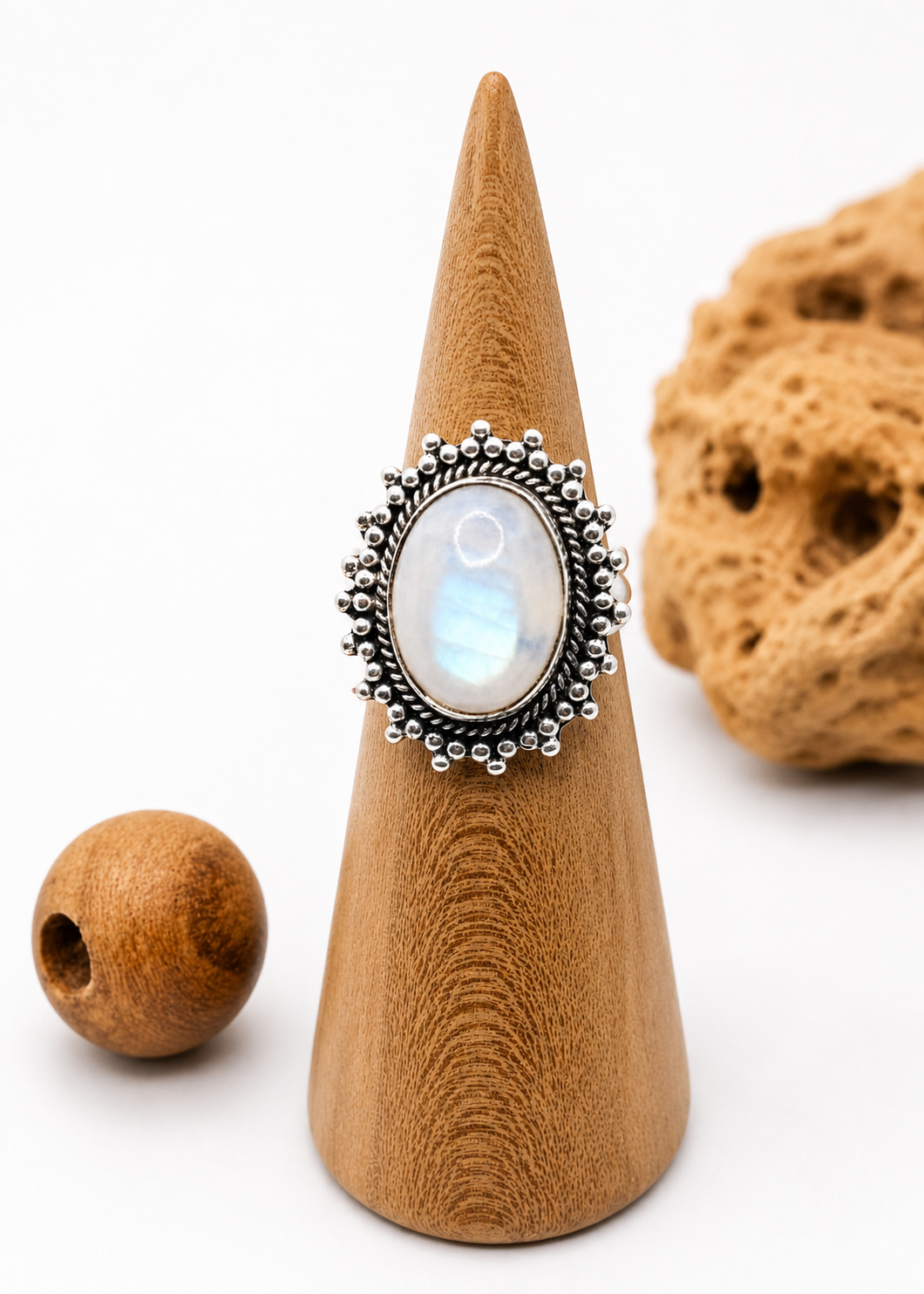Anello in argento con pietra di luna ovale iridescente su espositore in legno