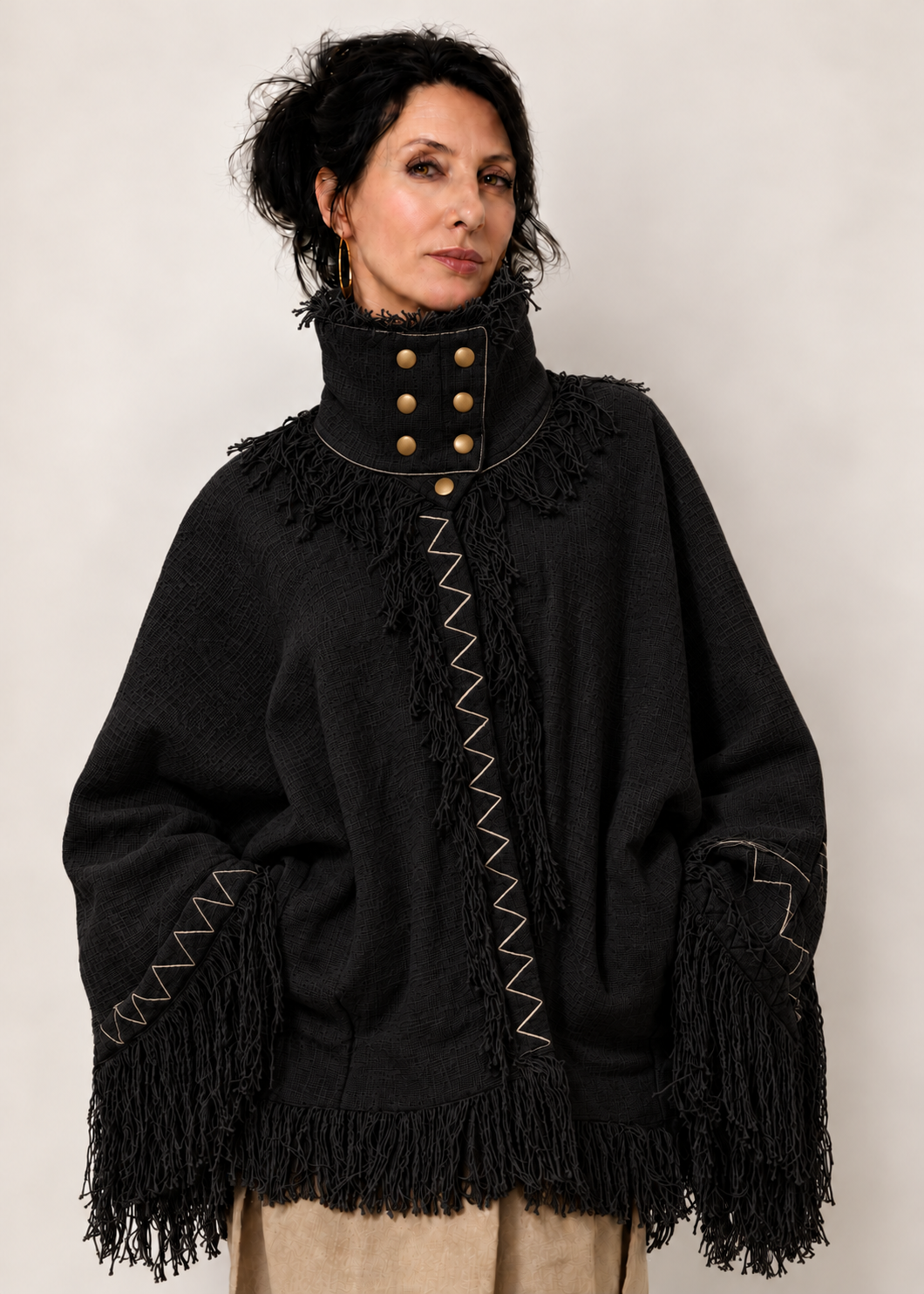 Fringe Poncho Nero in 100% cotone indossato, con collo strutturato, sette bottoni e frange.