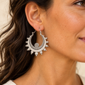 Orecchino Luna Radiante in bagno d’argento indossato, con doppia mezzaluna puntinata e decorazioni tonde; diametro 4,5 cm.